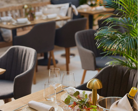 Dining room at Slanted Door Beaune with brass table lamps and greenery